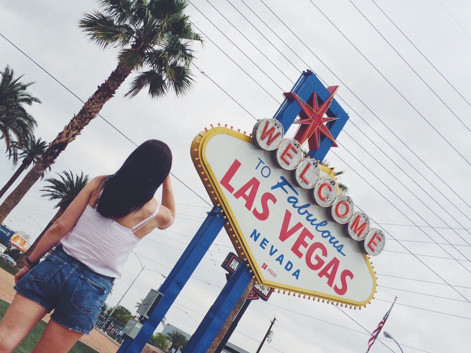 A girl standing in front of Welcome to fabulous Las Vegas sign, Las Vegas, Nevada, The USA