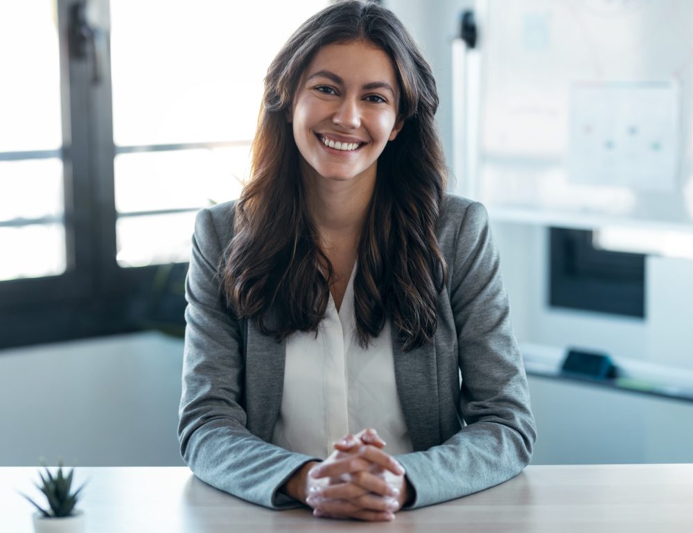 Confident business woman looking and speaking through the webcam while making a video conference